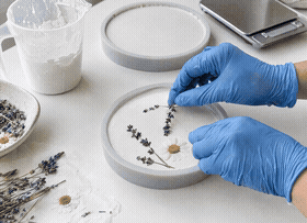Plaster flowers being placed on freshly poured aroma stones
